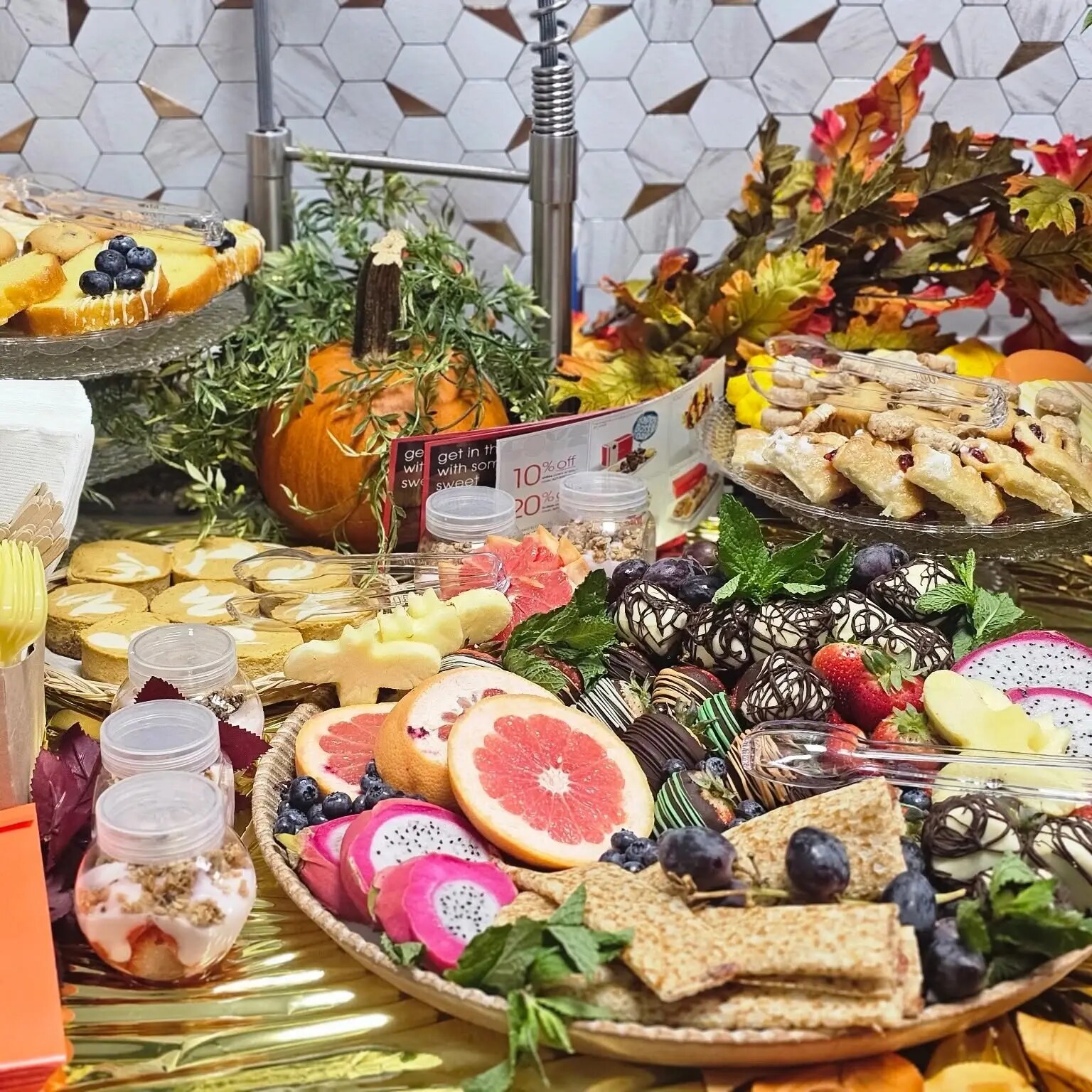 Autumn dessert graze with chocolate-dipped strawberries, dragon fruit, pastries and parfaits